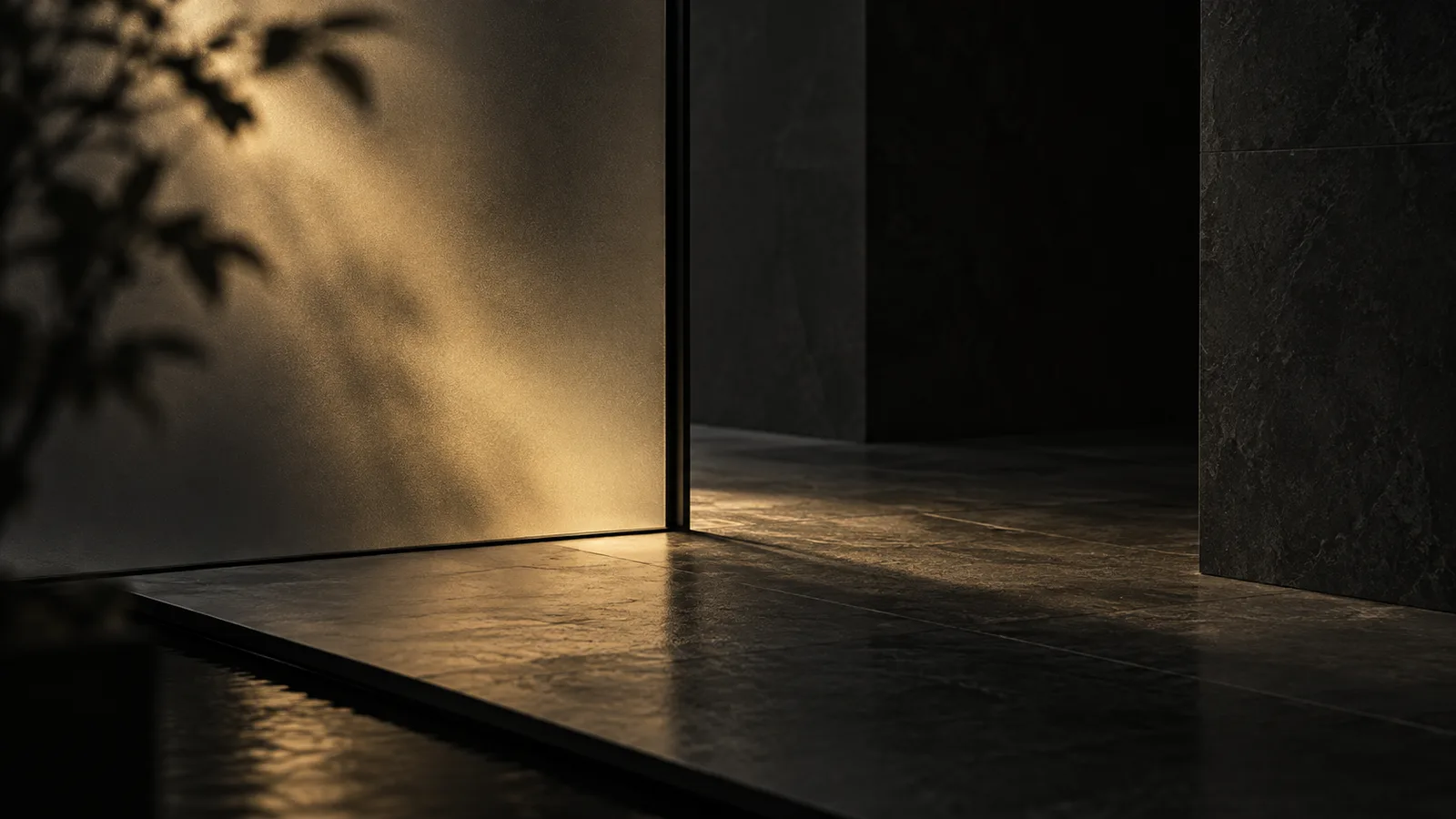 Soft gold light through a frosted glass partition onto a dark stone floor